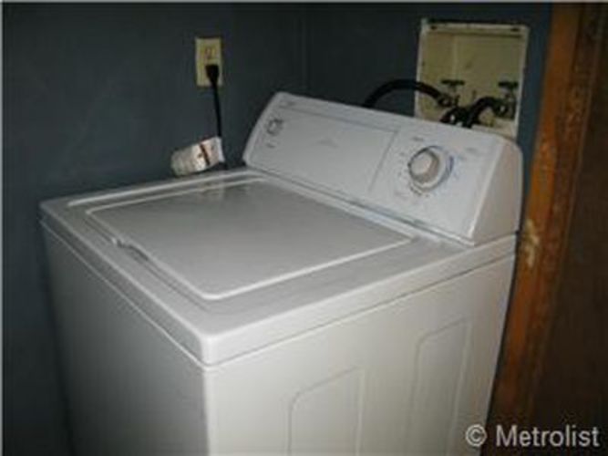 A white dryer sits in a room.