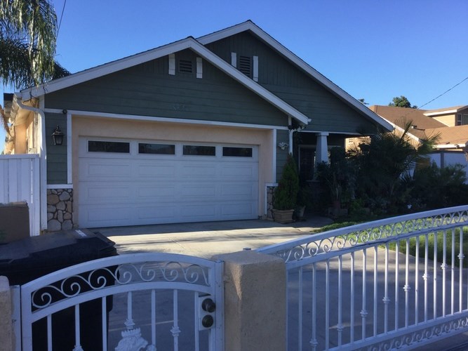 A house with a white garage door and a white fence.