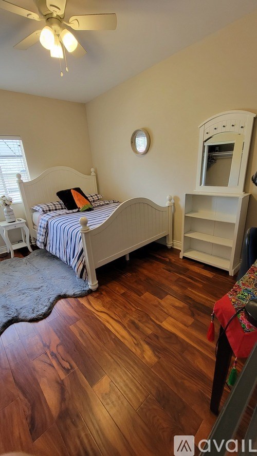 A bedroom with a bed, a dresser, and a window.