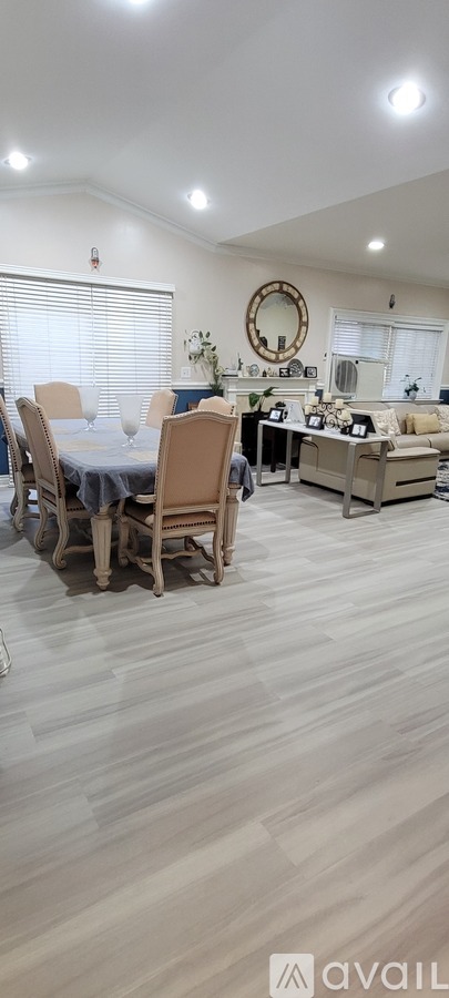A dining room with a table set for four and a couch.