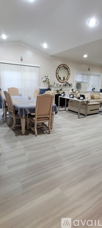 A dining room with a table set for four and a couch.