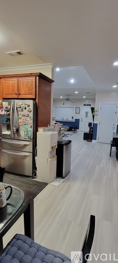 A kitchen with a refrigerator and a dining table.