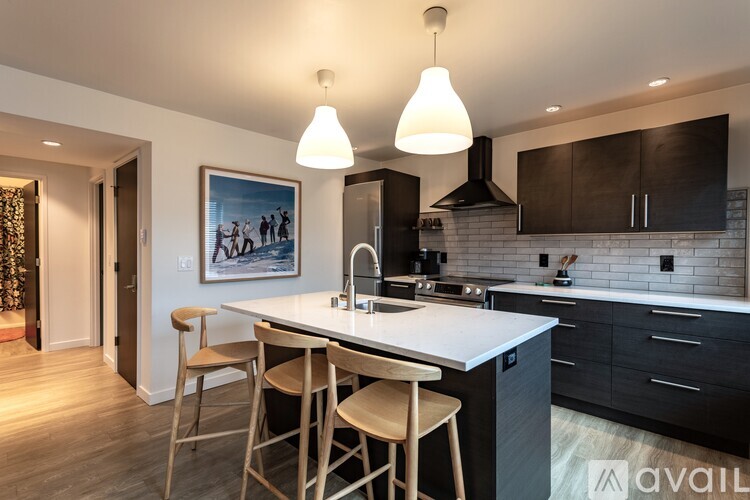 A kitchen with a white countertop and black cabinets.
