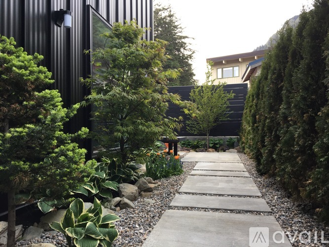 A garden pathway with a black building in the background.