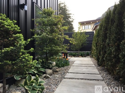A garden pathway with a black building in the background.