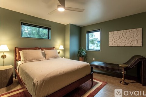 A bedroom with a large bed and a bench.