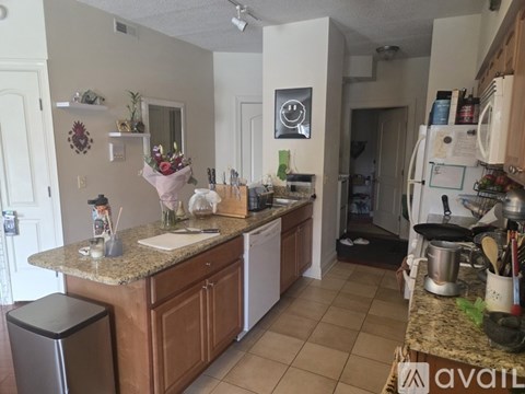 A kitchen with a granite countertop and white appliances.