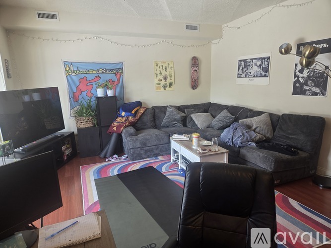 A living room with a grey couch and a television.