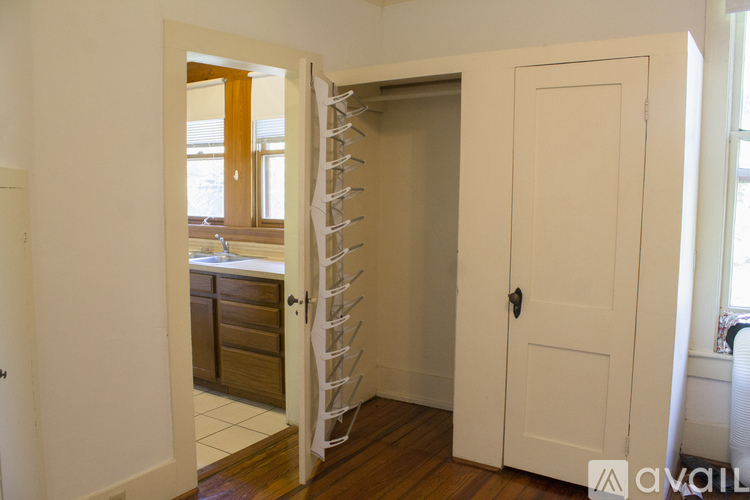 A white door is open to a room with a spiral staircase.