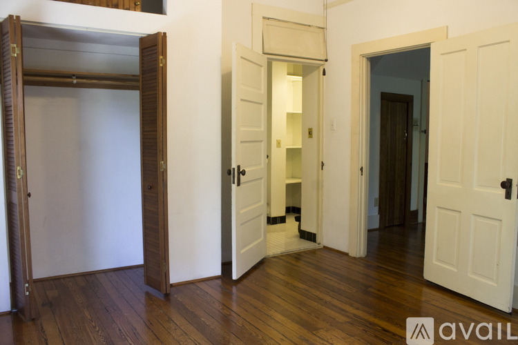 A room with a white door and a wooden floor.