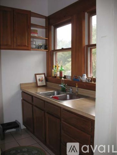 A kitchen with brown cabinets and a window.
