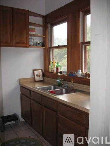 A kitchen with brown cabinets and a window.