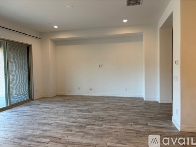 A room with a ceiling fan and a window with blinds.