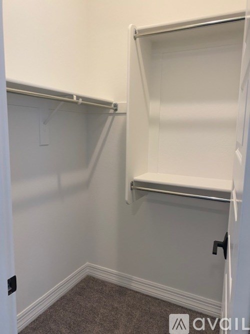 A white closet with shelves and a door.