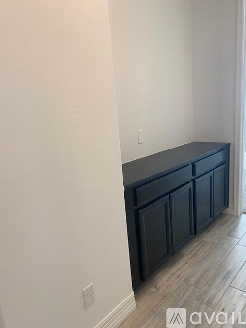 A dark blue cabinet sits against a white wall.