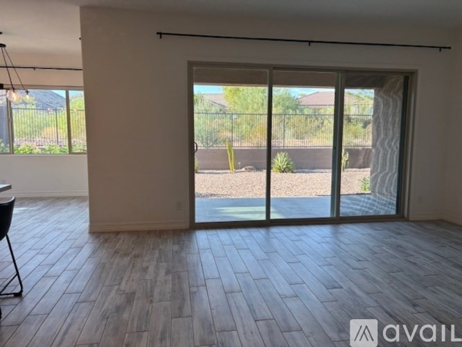 A spacious room with a view of a backyard through large windows.