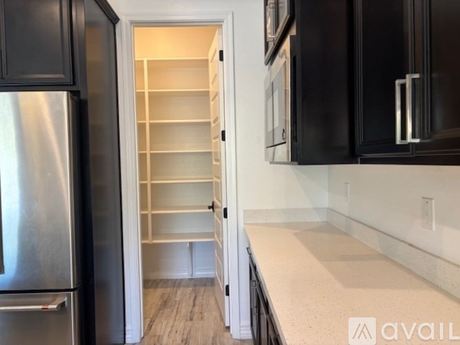 A bathroom with a glass shower door and a white tiled wall.