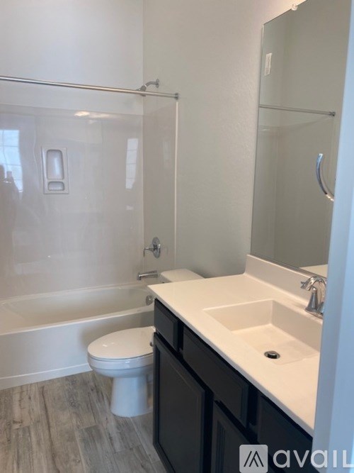 A bathroom with a toilet, sink, and shower.