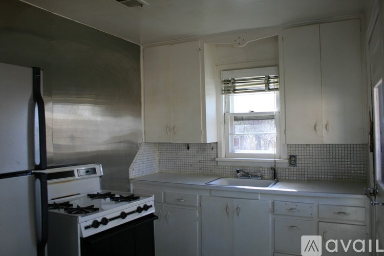 A kitchen with white cabinets and a black stove top oven.