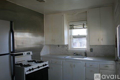 A kitchen with white cabinets and a black stove top oven.