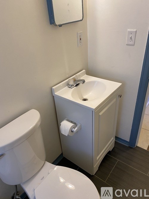 A white toilet sits next to a sink in a small bathroom.