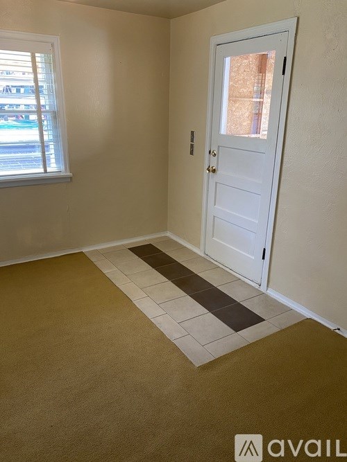 A room with a white door and a window with blinds.