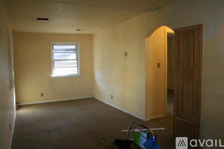 A room with a window and a door is available for rent.