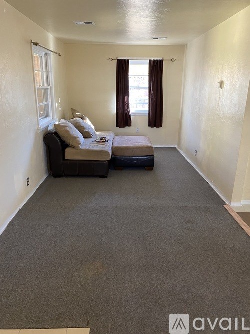 A bedroom with a bed and a window with curtains.