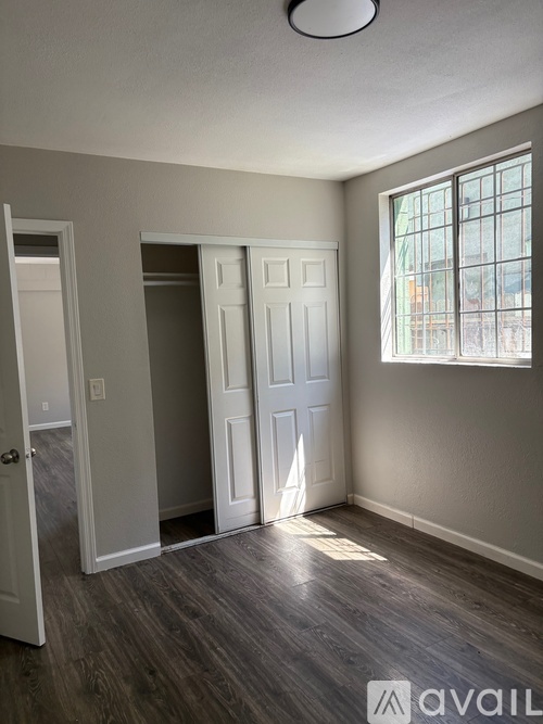 A kitchen with white cabinets and a black refrigerator.