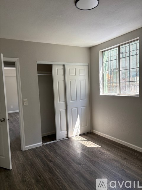 A kitchen with white cabinets and a black refrigerator.