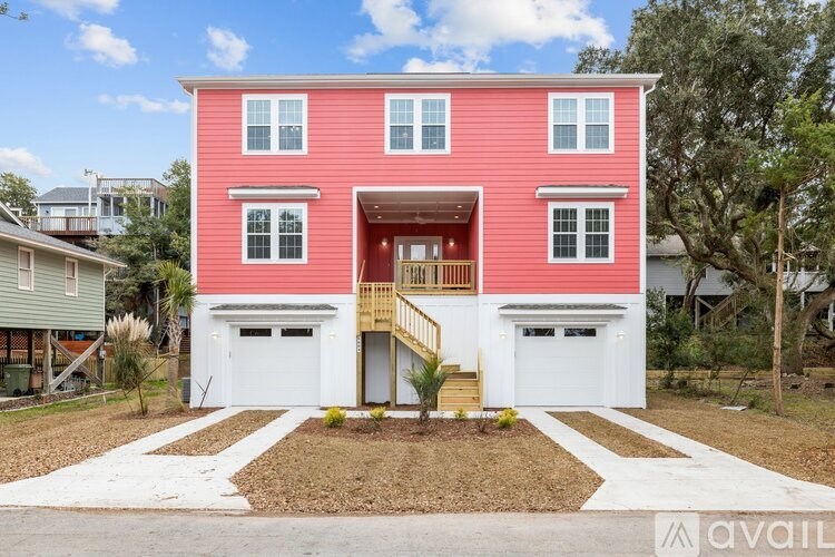 A pink house with a white garage door and a brown front yard.