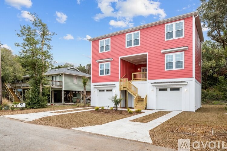 A red house with a white garage door and a brown driveway.