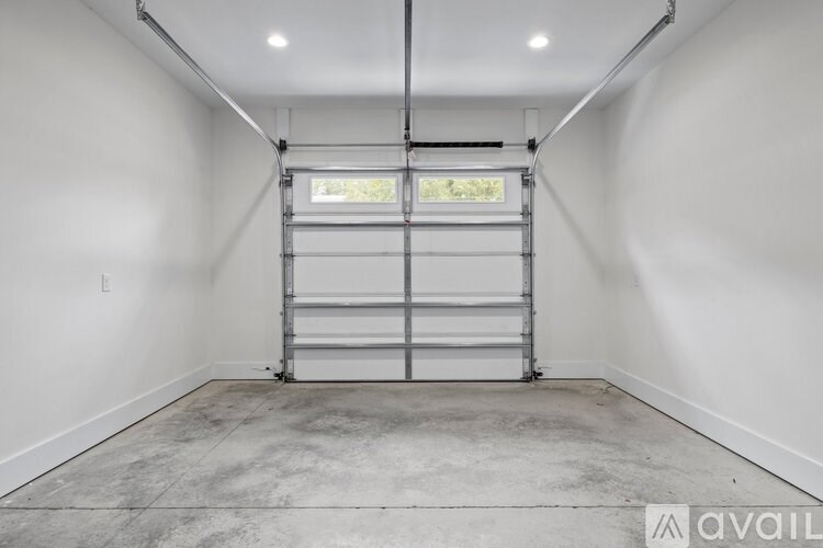 A large empty room with a metal shelving unit and a window.