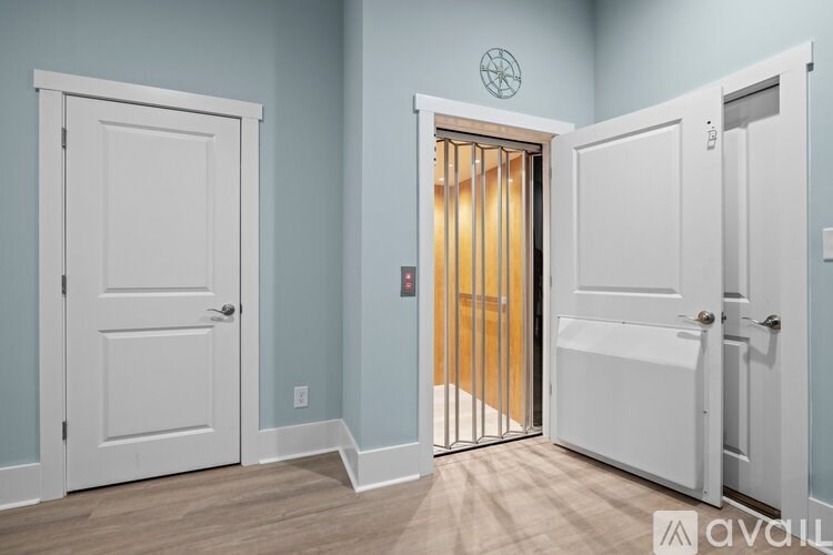 A room with a white door and a white door with bars on it.