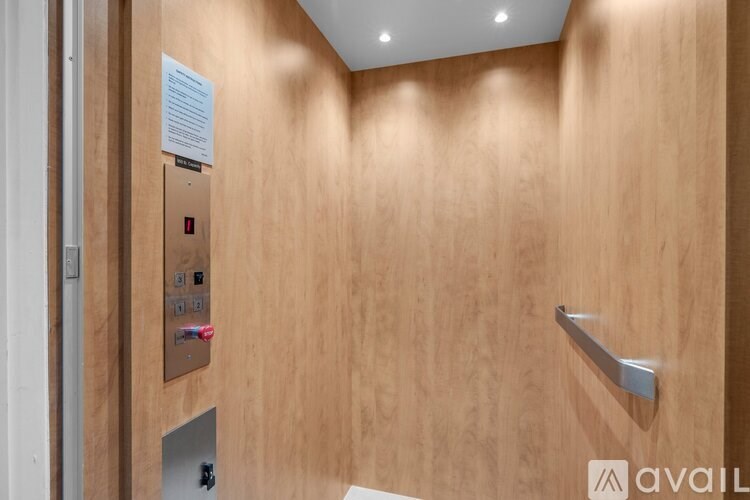 A wooden wall with a metal handle and a paper attached to it.