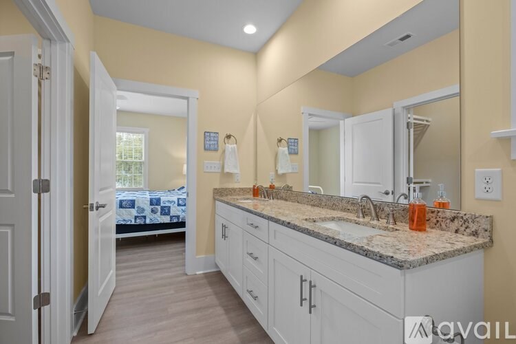 A bathroom with a vanity, sink, and mirror.