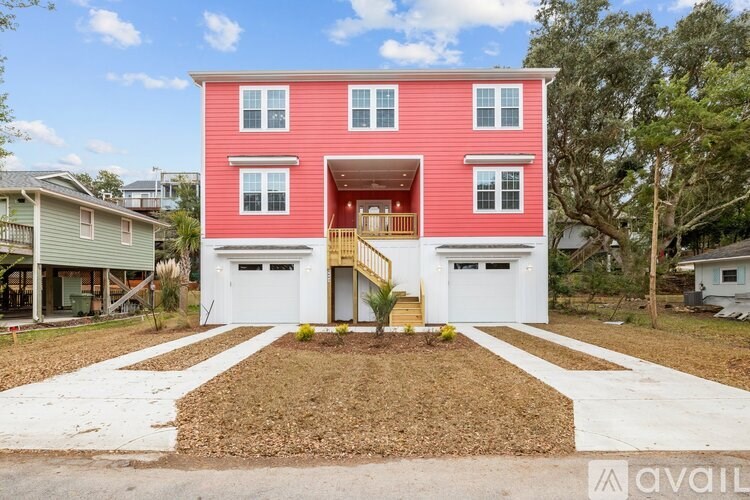A red house with a white garage door is for sale.
