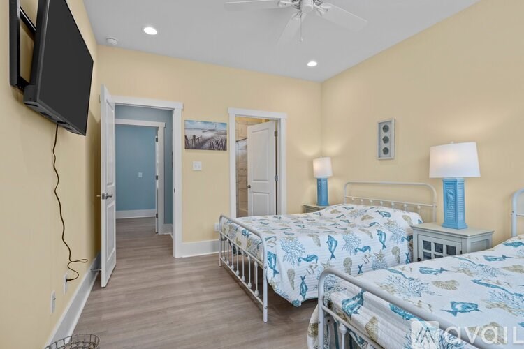 A bedroom with two beds and a television mounted on the wall.