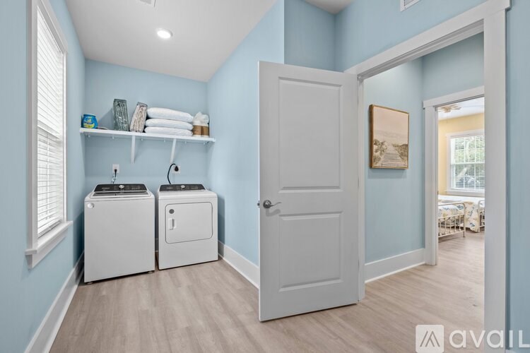 A bathroom with light blue walls and a white door.