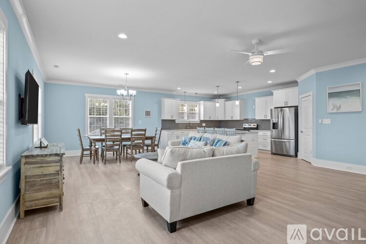 A living room with a couch, chairs, and a television.