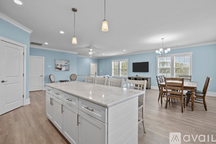 A kitchen with a large island and wooden floors.