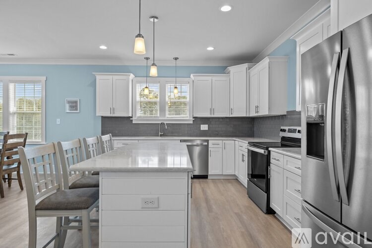 A kitchen with a large island and stainless steel appliances.