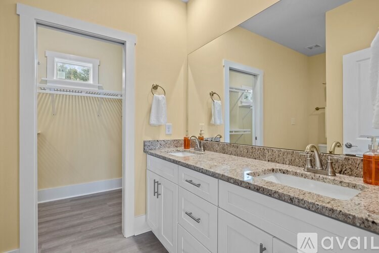 A bathroom with a double sink vanity and a large mirror.