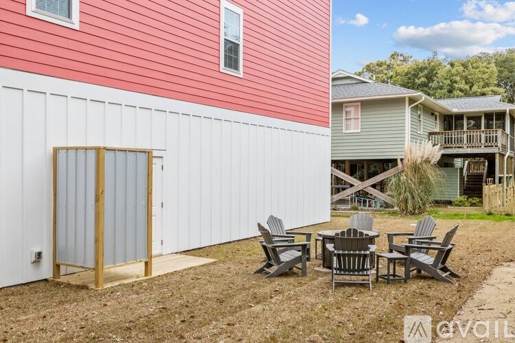 A red and white house with a patio table and chairs.