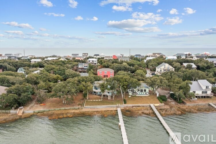 A bird's eye view of a coastal town with houses and a pier.