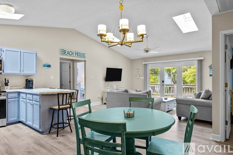 A dining room with a green table and chairs.