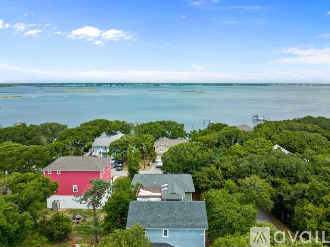 A bird's eye view of a coastal neighborhood with houses and trees.