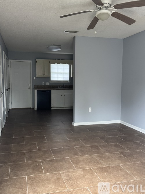 A room with a ceiling fan and tile flooring.