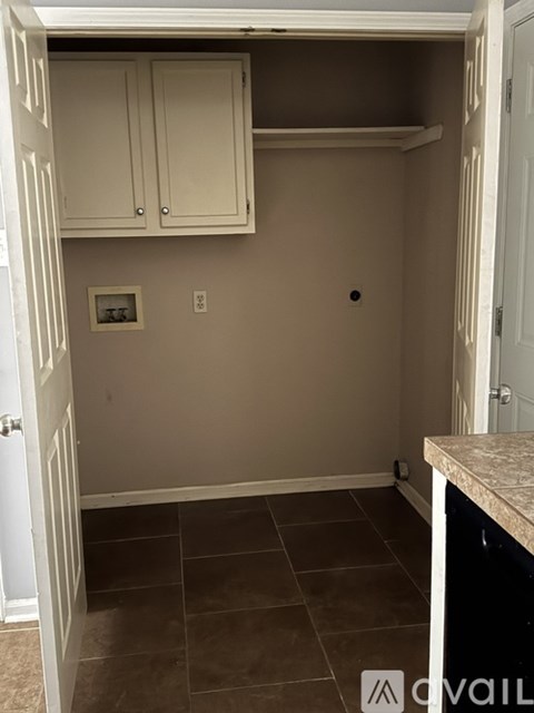 A kitchen with white cabinets and a tiled floor.
