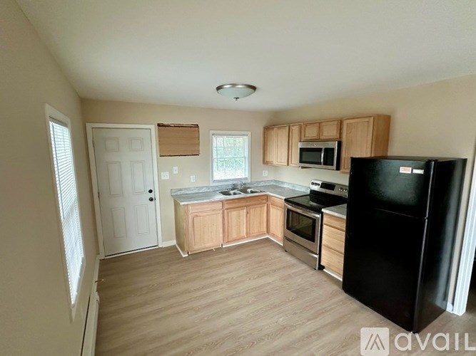 A kitchen with wooden cabinets and black appliances.